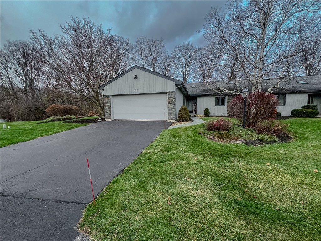 single story home featuring a garage and a front yard