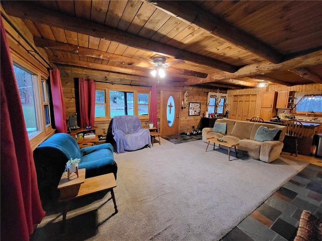 living room with beamed ceiling, ceiling fan, wooden ceiling, and wooden walls