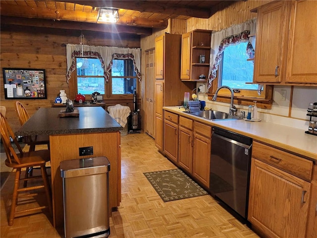 kitchen featuring black dishwasher, a kitchen island, a healthy amount of sunlight, and wood walls