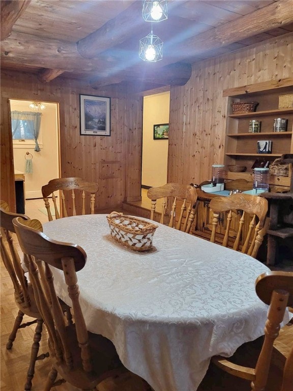 dining area with wood walls and wooden ceiling