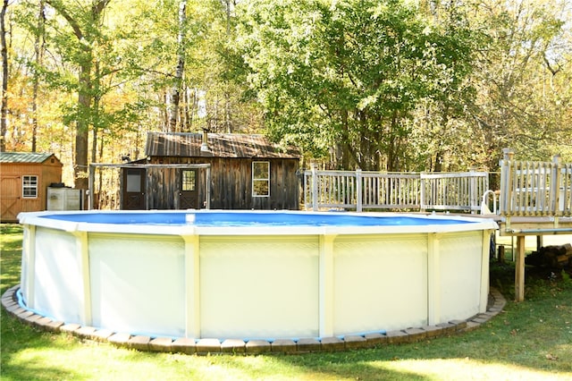 view of swimming pool with a storage shed and a wooden deck