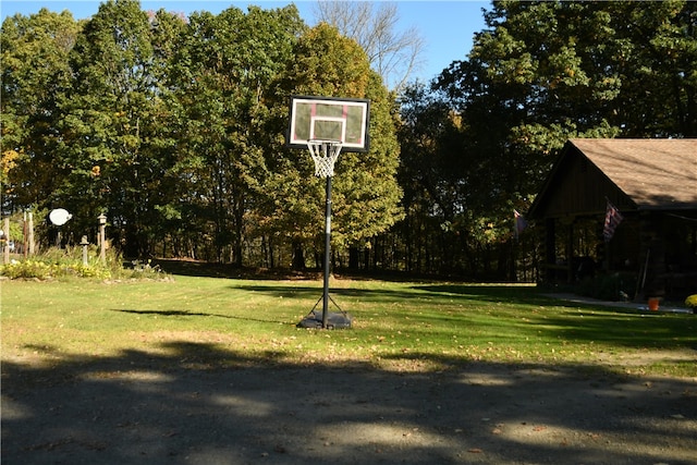 view of sport court with a lawn