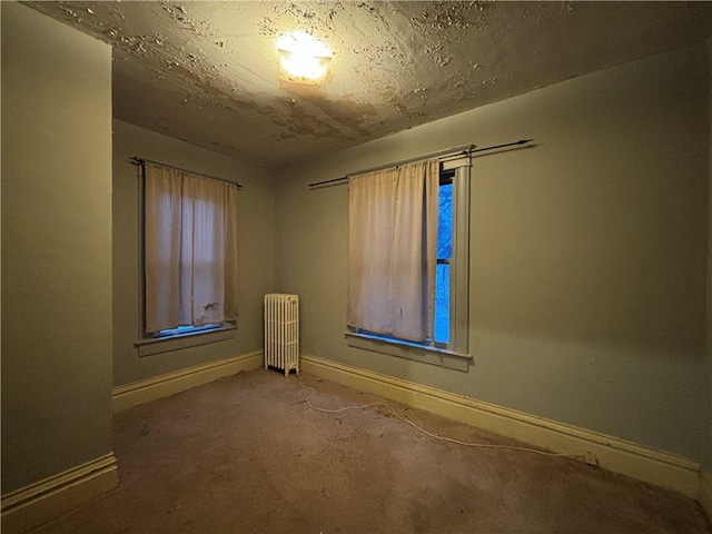 carpeted empty room with radiator heating unit