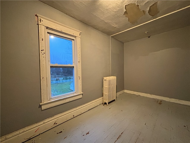 interior space featuring radiator heating unit and hardwood / wood-style floors