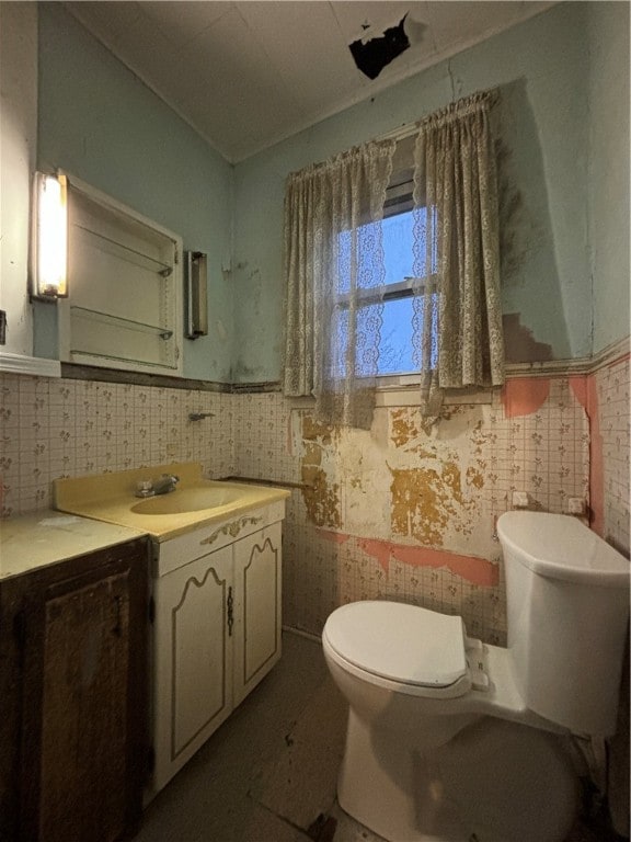 bathroom featuring vanity, toilet, and tile walls