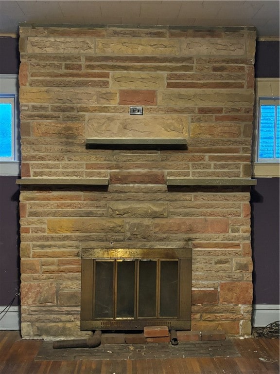 room details featuring a stone fireplace and hardwood / wood-style floors