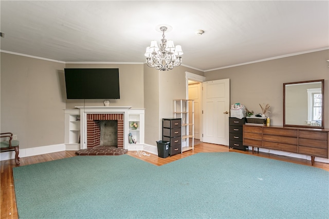 living room with hardwood / wood-style floors, a chandelier, ornamental molding, and a brick fireplace