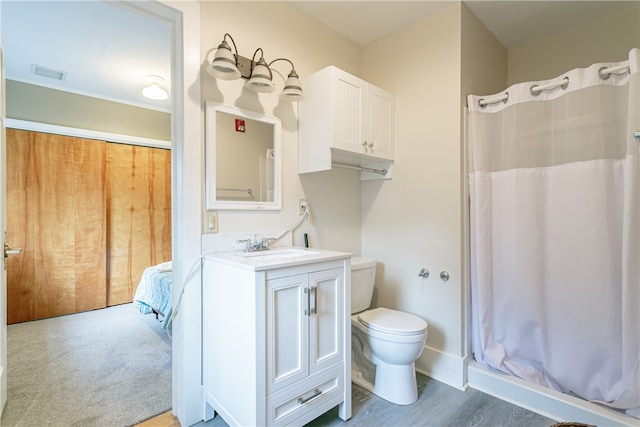 bathroom with hardwood / wood-style floors, vanity, toilet, and a shower with curtain