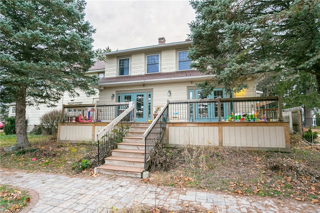 view of front facade with a wooden deck and french doors