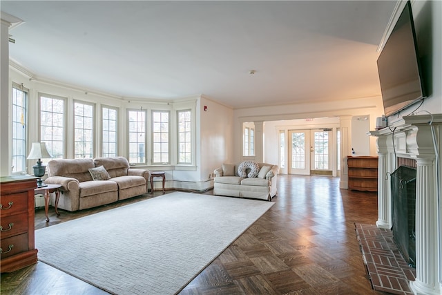 living room featuring dark parquet flooring, ornamental molding, and french doors