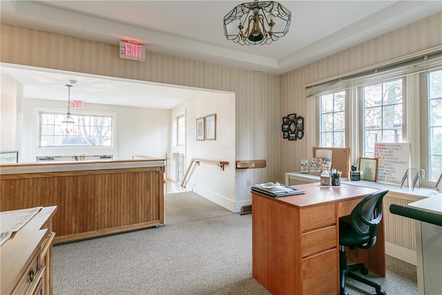 carpeted home office with an inviting chandelier