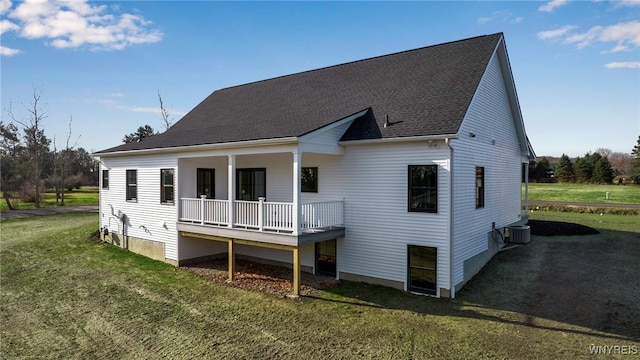 back of property featuring covered porch, central air condition unit, and a lawn