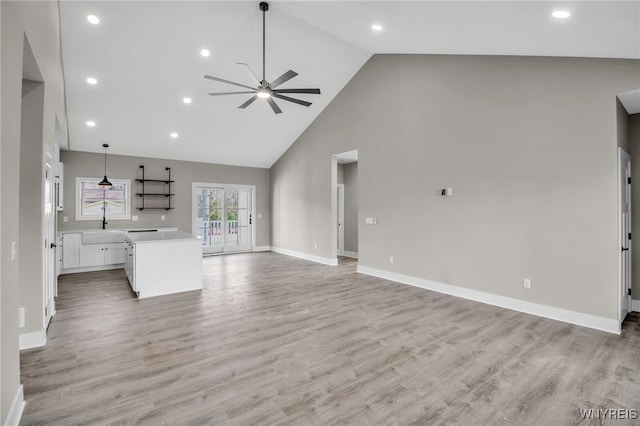 unfurnished living room featuring light hardwood / wood-style floors, high vaulted ceiling, and ceiling fan