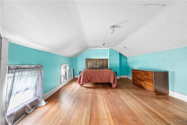 bedroom featuring light wood-type flooring and vaulted ceiling