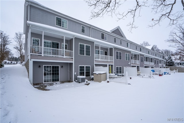 snow covered house featuring central AC unit