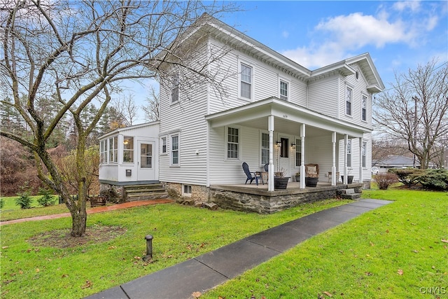 view of front facade featuring covered porch, a front lawn, and a sunroom