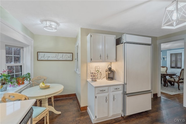 kitchen featuring white cabinetry, tasteful backsplash, dark hardwood / wood-style flooring, refrigerator, and pendant lighting