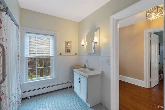 bathroom featuring hardwood / wood-style flooring, vanity, and baseboard heating