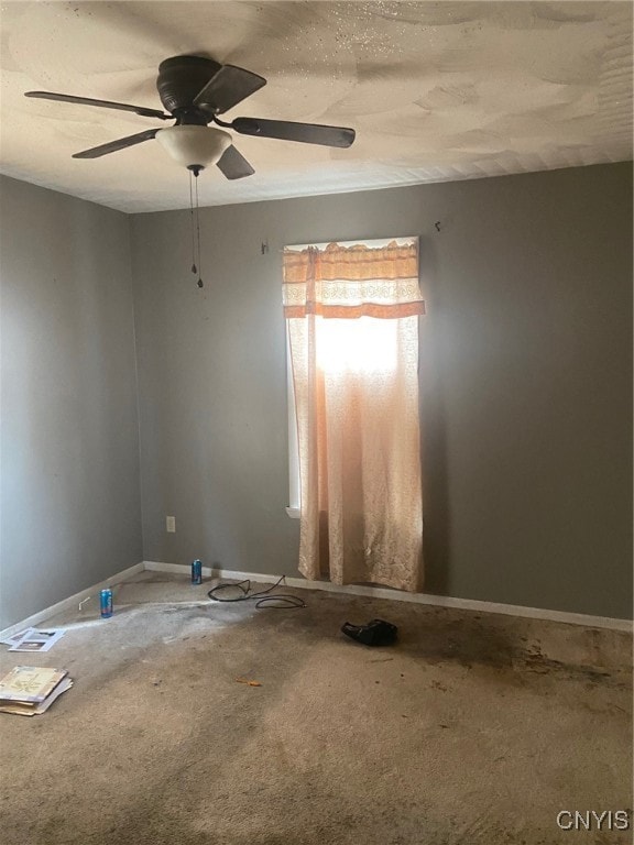 carpeted empty room with ceiling fan and a textured ceiling