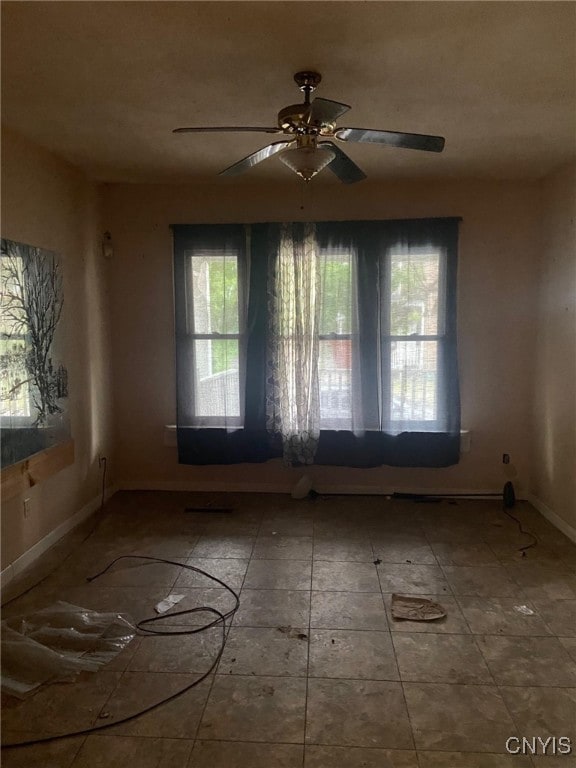 spare room featuring plenty of natural light and ceiling fan