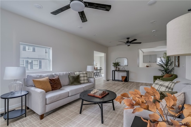 living room with light hardwood / wood-style floors and ceiling fan