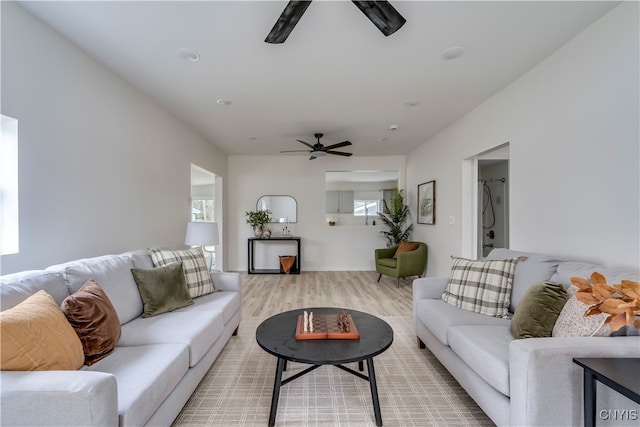 living room with light hardwood / wood-style floors and ceiling fan