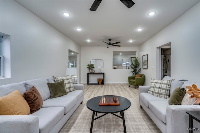 living room featuring ceiling fan and light hardwood / wood-style floors