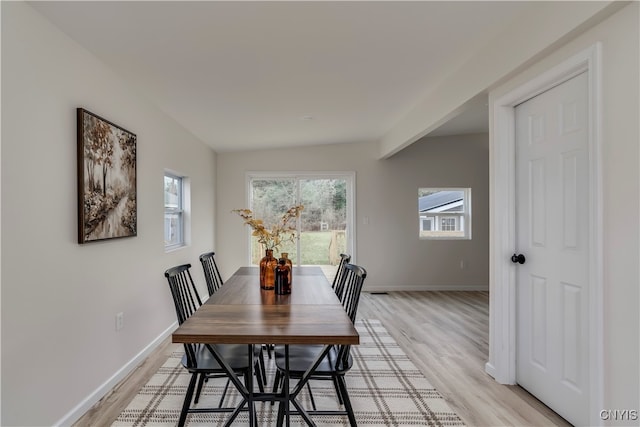 dining room with light hardwood / wood-style floors and lofted ceiling