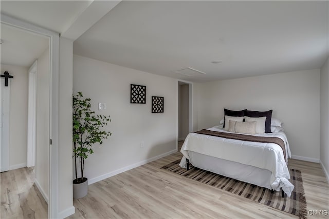 bedroom featuring a barn door and light hardwood / wood-style floors