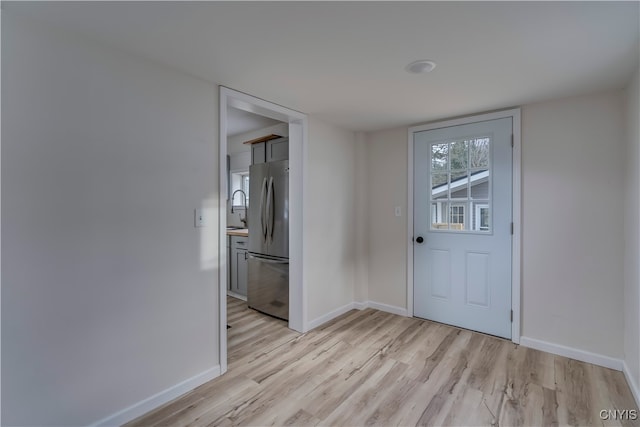 foyer entrance with light hardwood / wood-style flooring and sink