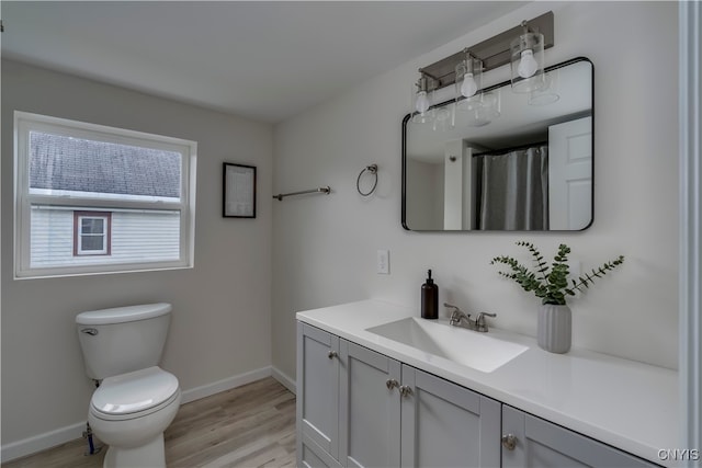 bathroom with hardwood / wood-style floors, vanity, and toilet