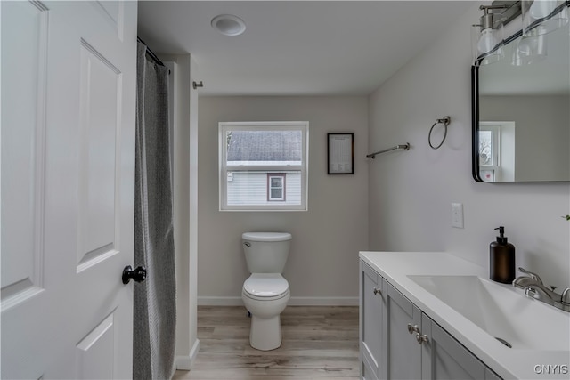 bathroom featuring wood-type flooring, vanity, and toilet