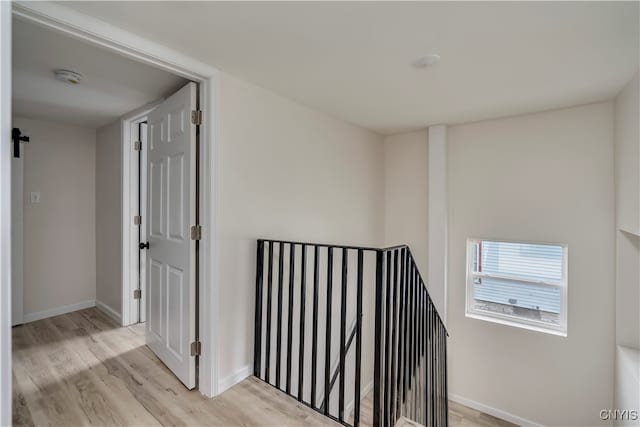 hallway with a barn door and light wood-type flooring