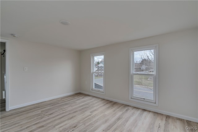 unfurnished room featuring light hardwood / wood-style floors and plenty of natural light