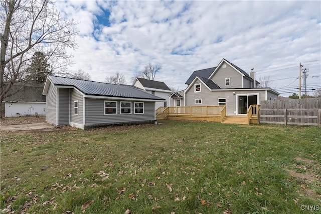 rear view of property featuring a lawn and a deck