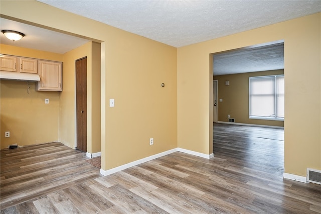 empty room featuring light hardwood / wood-style floors and a textured ceiling