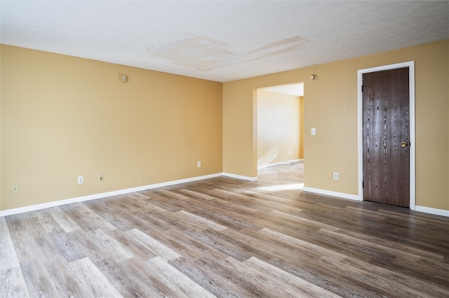 unfurnished room featuring wood-type flooring and a textured ceiling