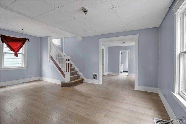 unfurnished room with a paneled ceiling and light hardwood / wood-style floors