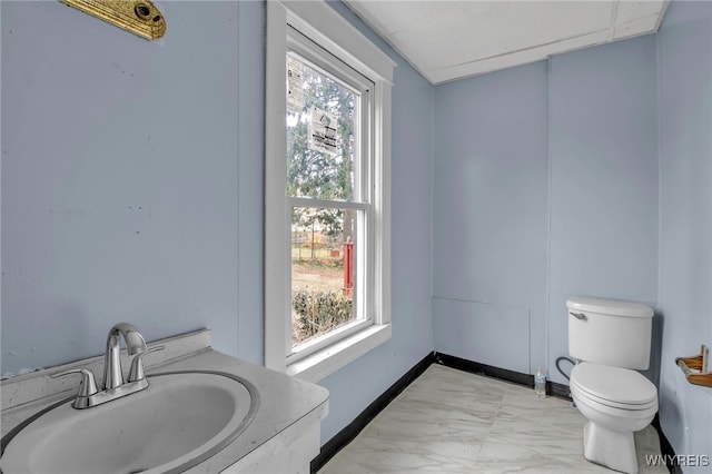 bathroom featuring vanity, a healthy amount of sunlight, and toilet