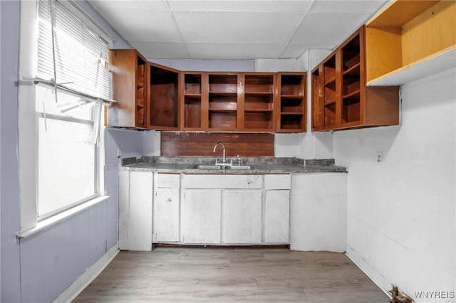 kitchen featuring light hardwood / wood-style floors, white cabinetry, and sink