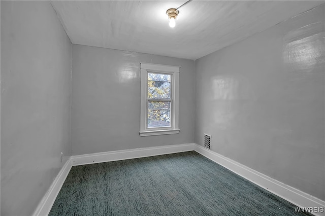 spare room featuring dark colored carpet