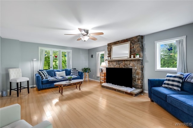 living room featuring a wealth of natural light, a fireplace, ceiling fan, and hardwood / wood-style flooring