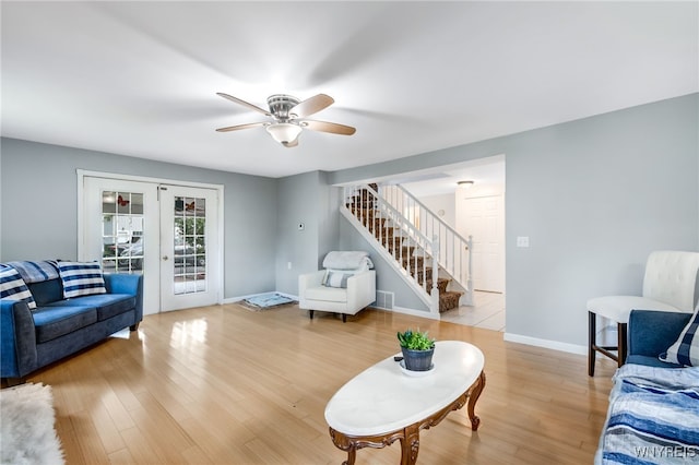 living room featuring french doors, light wood-type flooring, and ceiling fan