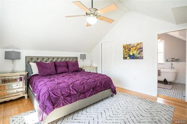 bedroom featuring ensuite bath, lofted ceiling, and hardwood / wood-style flooring