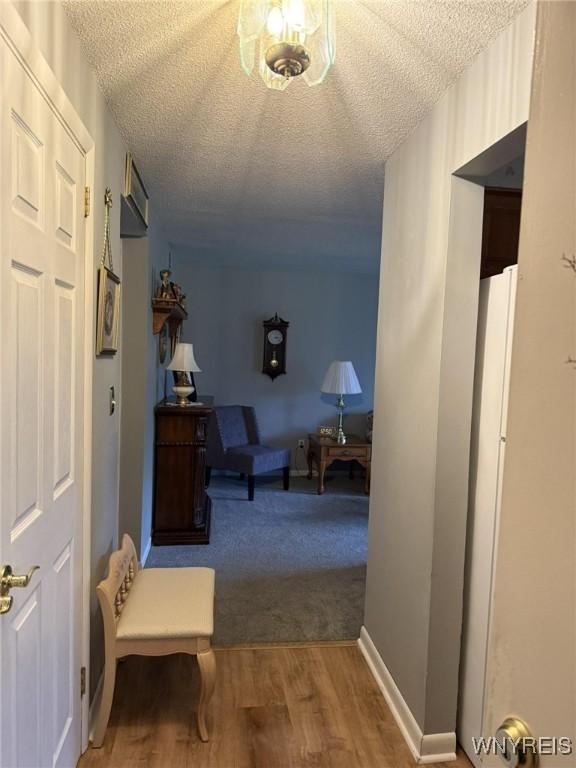 hall with a textured ceiling and hardwood / wood-style flooring