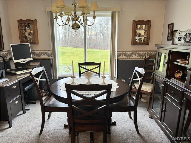 carpeted dining area featuring a chandelier