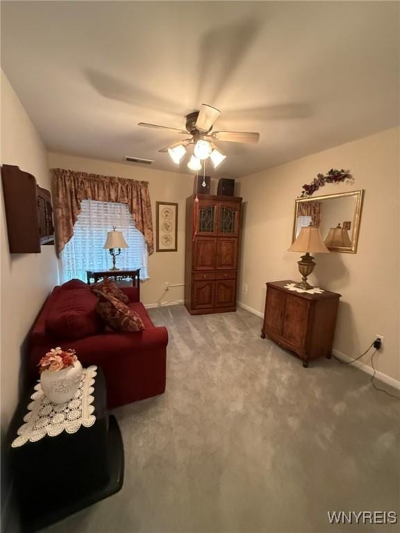 living area featuring light carpet and ceiling fan