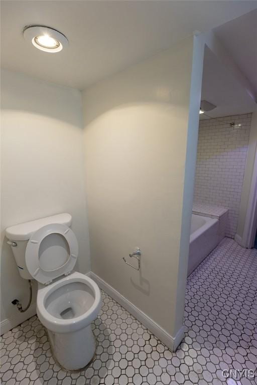 bathroom with tile patterned floors, a bathing tub, and toilet