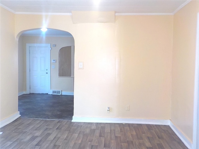 spare room featuring ornamental molding and dark wood-type flooring