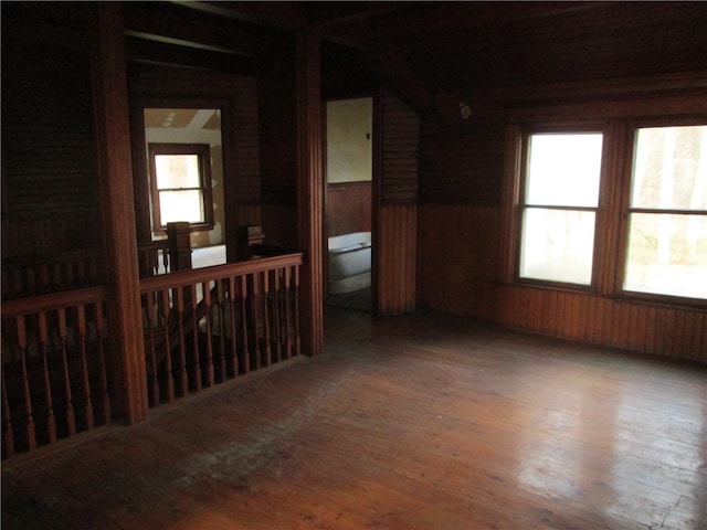 unfurnished room featuring wood walls and hardwood / wood-style flooring